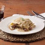 Lasaña fácil con espinacas, salchichas, cebolla confitada y setas